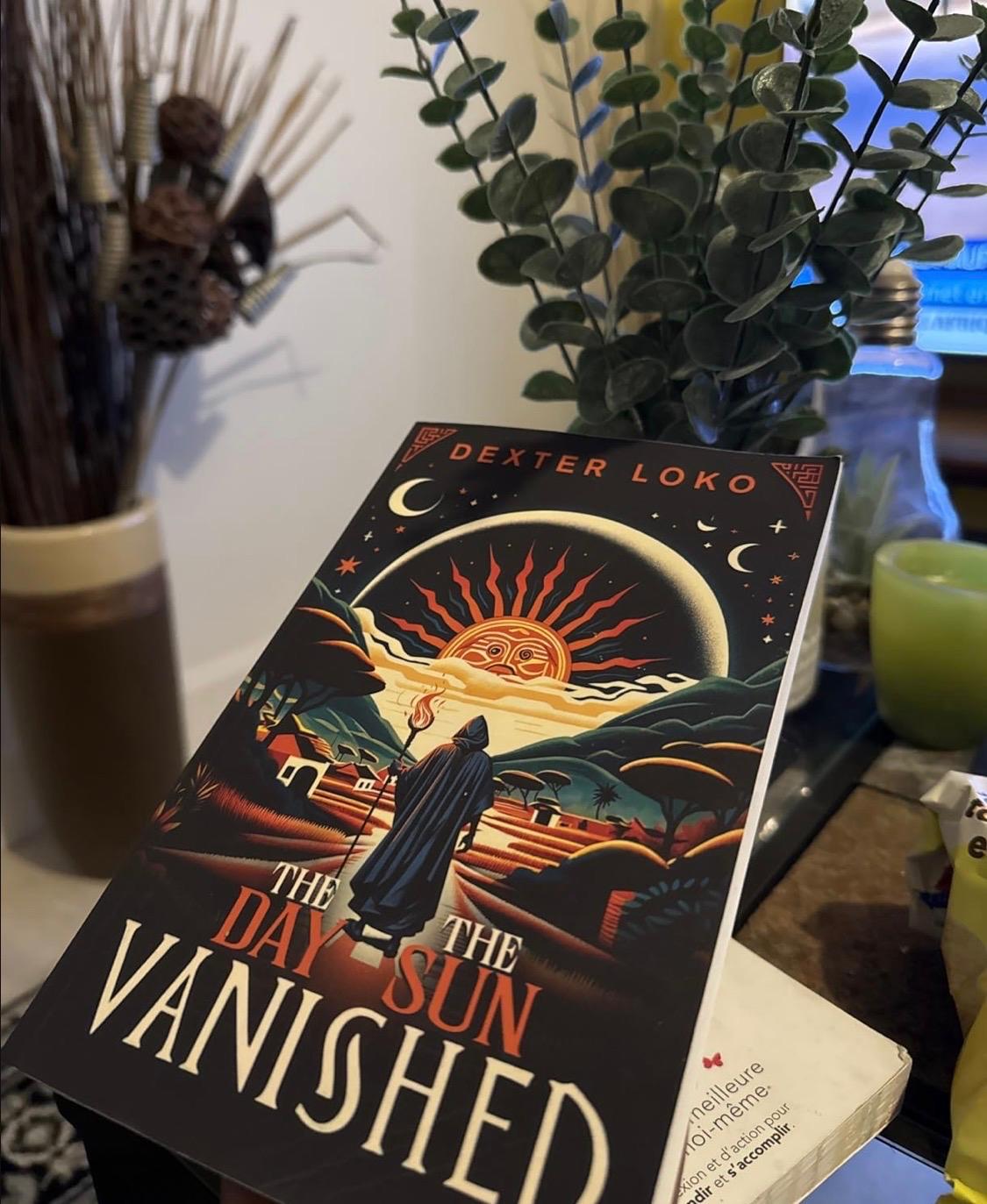 A copy of The Day the Sun Vanished displayed among plants and home objects.